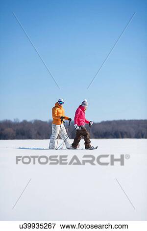 Stock Photo - Adult couple walking on snow. Fotosearch