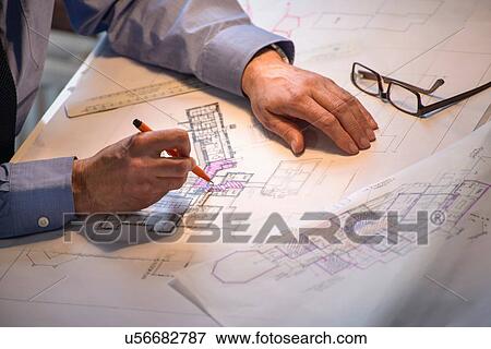 Architect drawing plans at drawing board, close up View Large Photo Image Stock Photo - Architect drawing plans at drawing board, close up. Fotosearch
