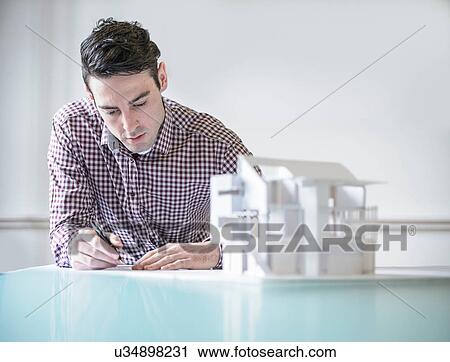 Architect working next to model building View Large Photo Image Stock Image - Architect working next to model building. Fotosearch