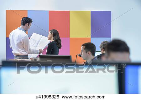 Stock Photography - Architects discussing plans together in office. Fotosearch
