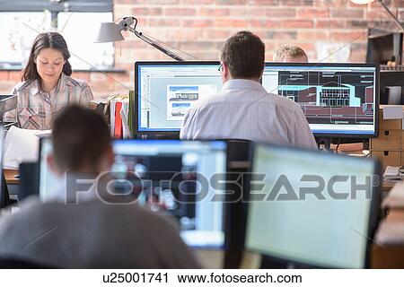 Architects working on monitors in modern office View Large Photo Image Stock Image - Architects working on monitors in modern office. Fotosearch
