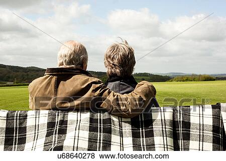 Back view of senior couple enjoying scenery on field View Large Photo Image Stock Photo - Back view of senior couple enjoying scenery on field. Fotosearch