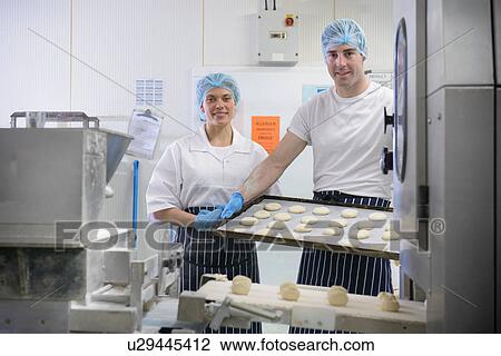 Bakers holding tray of prepared dough, portrait View Large Photo Image Stock Image - Bakers holding tray of prepared dough, portrait. Fotosearch