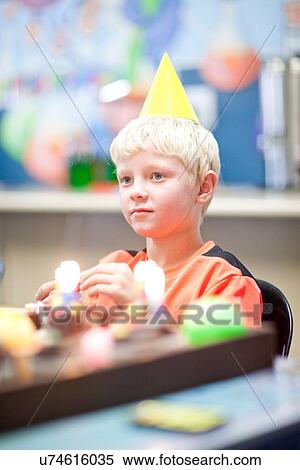 Stock Photography - Boy at birthday party wearing party hat. Fotosearch
