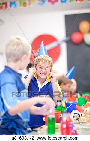 Boy at birthday party with fingers in ears View Large Photo Image Stock Image - Boy at birthday party with fingers in ears. Fotosearch