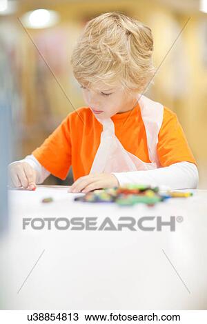 Stock Image - Boy concentrating on drawing. Fotosearch