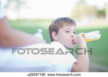 Boy drinking soft drink during game of cricket View Large Photo Image Stock Image - Boy drinking soft drink during game of cricket. Fotosearch