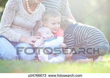 Stock Image - Boy holding baby sister. Fotosearch