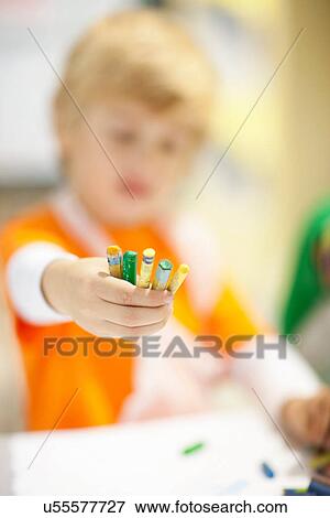 Stock Photo - Boy holding out crayons. Fotosearch