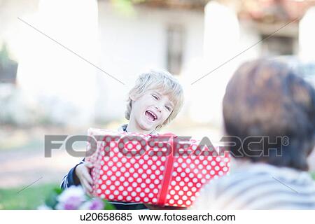 Boy holding spotty birthday gift View Large Photo Image Stock Photography - Boy holding spotty birthday gift. Fotosearch