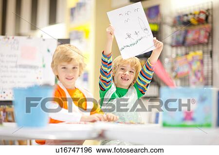 Boy holding up his drawing View Large Photo Image Stock Photograph - Boy holding up his drawing. Fotosearch