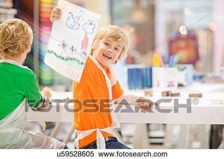 Stock Photography - Boy holding up his drawing. Fotosearch