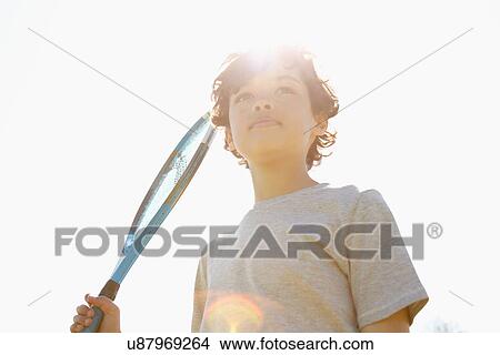 Boy holding up tennis racket View Large Photo Image Picture - Boy holding up tennis racket. Fotosearch