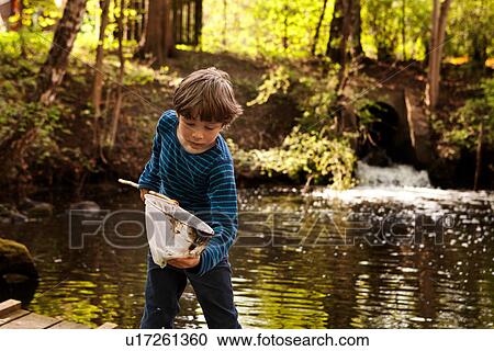 Boy looking into fishing net View Large Photo Image Stock Image - Boy looking into fishing net. Fotosearch