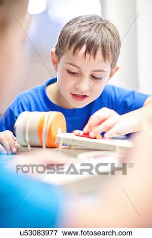 Boy making craft object View Large Photo Image Stock Photo - Boy making craft object. Fotosearch