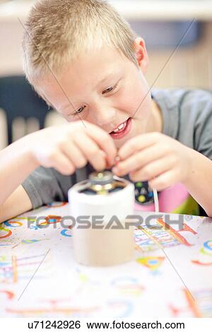 Stock Photograph - Boy making craft object. Fotosearch