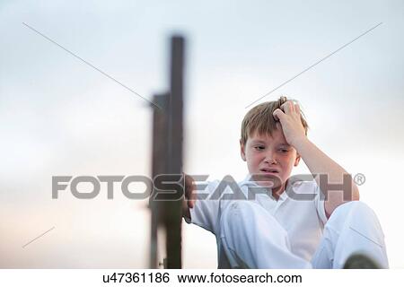 Boy on bleachers at cricket pitch scratching head View Large Photo Image Stock Photograph - Boy on bleachers at cricket pitch scratching head. Fotosearch