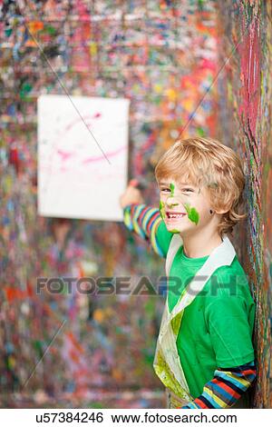 Boy pointing to painting on paint-splattered wall View Large Photo Image Stock Photograph - Boy pointing to painting on paint-splattered wall. Fotosearch