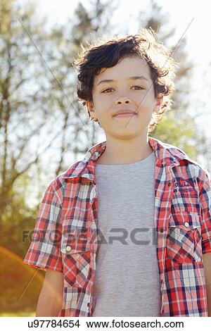 Boy wearing checked shirt in park View Large Photo Image Picture - Boy wearing checked shirt in park. Fotosearch