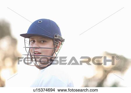 Picture - Boy wearing cricket helmet, portrait. Fotosearch