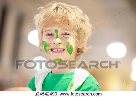Stock Image - Boy with green paint on his face. Fotosearch