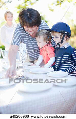 Boys and grandmother setting dinner table outdoors View Large Photo Image Stock Photograph - Boys and grandmother setting dinner table outdoors. Fotosearch