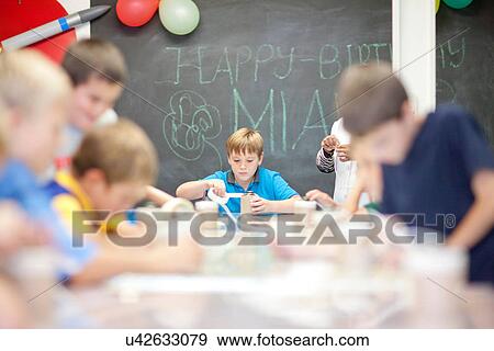 Stock Photo - Boys making objects at children's birthday party. Fotosearch