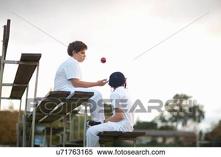 Stock Photography - Boys on bleachers at cricket pitch. Fotosearch