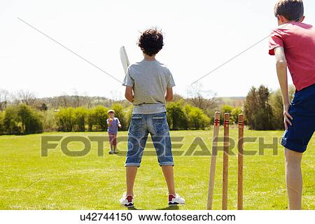 Boys playing cricket on field View Large Photo Image Stock Image - Boys playing cricket on field. Fotosearch