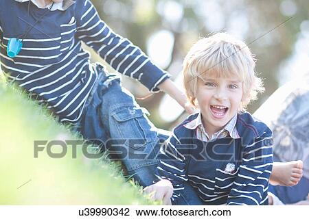Stock Image - Boys playing on grass. Fotosearch