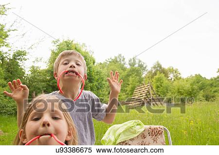 Brother and sister biting on liquorice View Large Photo Image Stock Photography - Brother and sister biting on liquorice. Fotosearch