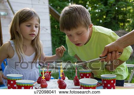 Stock Image - Brother and sister with birthday cake. Fotosearch