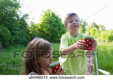 Stock Image - Brother and sister with picnic cups. Fotosearch