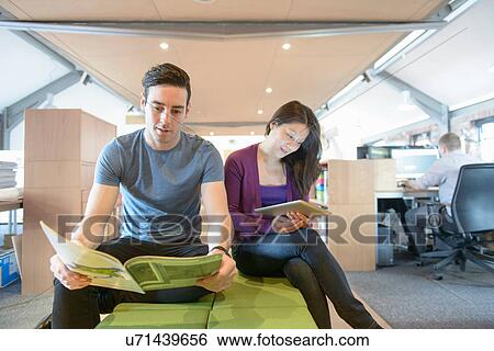 Stock Photograph - Business colleagues taking a break in modern office. Fotosearch