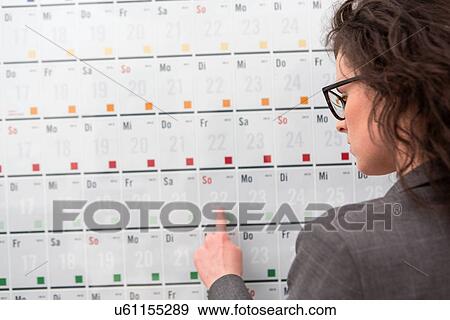 Businesswoman pointing to date on calendar View Large Photo Image Stock Photo - Businesswoman pointing to date on calendar. Fotosearch