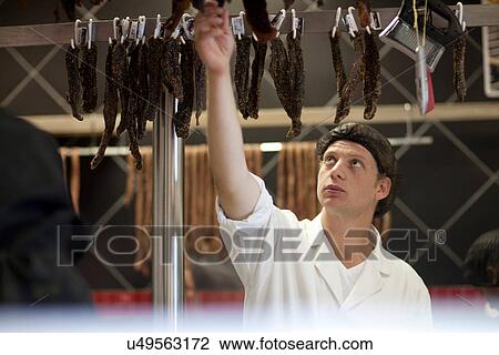 Stock Image - Butcher reaching up. Fotosearch