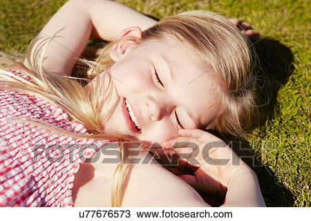 Child lying down on grass View Large Photo Image Stock Image - Child lying down on grass. Fotosearch