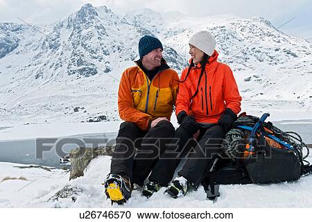 Climbing couple taking a break in front of snow covered mountains, Devils kitchen, llyn Idwal, Cwm Idwal, Snowdonia View Large Photo Image Stock Image - Climbing couple taking a break in front of snow covered mountains, Devils kitchen, llyn Idwal, Cwm Idwal, Snowdonia. Fotosearch