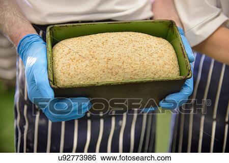 Close up of baker holding unbaked bread in tin View Large Photo Image Stock Photograph - Close up of baker holding unbaked bread in tin. Fotosearch