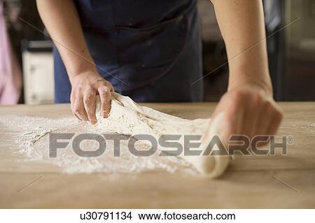 Picture - Close up of hands stretching bread dough. Fotosearch