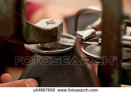 Close up of person using machine to work leather View Large Photo Image Stock Image - Close up of person using machine to work leather. Fotosearch