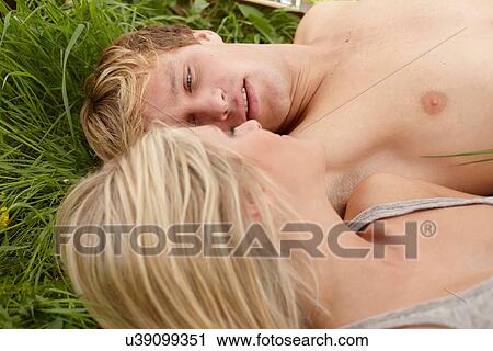 Close up of young couple lying face to face on grass View Large Photo Image Stock Image - Close up of young couple lying face to face on grass. Fotosearch