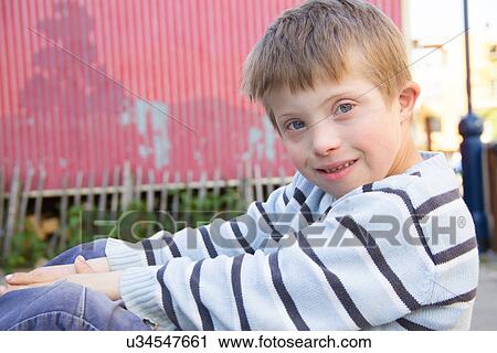 Stock Image - Close up portrait of boy sitting outside. Fotosearch