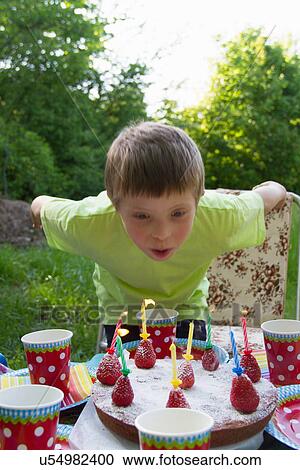 Close up portrait of young boy blowing out birthday candles View Large Photo Image Stock Image - Close up portrait of young boy blowing out birthday candles. Fotosearch