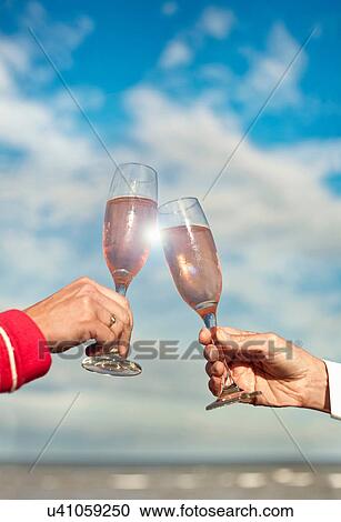 Couple toasting with pink champagne View Large Photo Image Stock Image - Couple toasting with pink champagne. Fotosearch