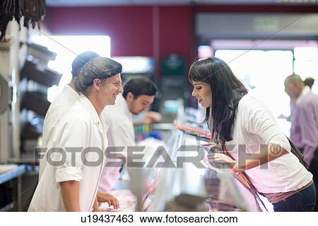 Customer choosing from butcher's counter View Large Photo Image Stock Image - Customer choosing from butcher's counter. Fotosearch