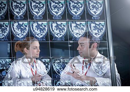 Stock Photo - Doctors discussing computed tomography (CT) scans on screen. Fotosearch