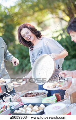 Family and friends at barbecue View Large Photo Image Picture - Family and friends at barbecue. Fotosearch