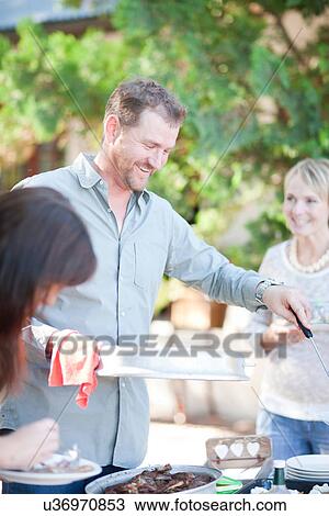 Family and friends at barbecue View Large Photo Image Stock Image - Family and friends at barbecue. Fotosearch