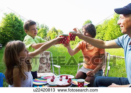 Stock Image - Family celebrating birthday outdoors. Fotosearch